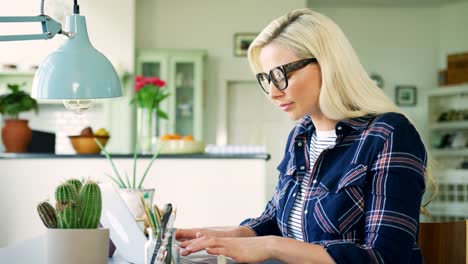 Attractive-Blond-Businesswoman-Typing-On-Laptop-At-Home-Office