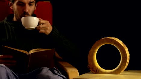 man-drinking-tea-next-to-the-lamp