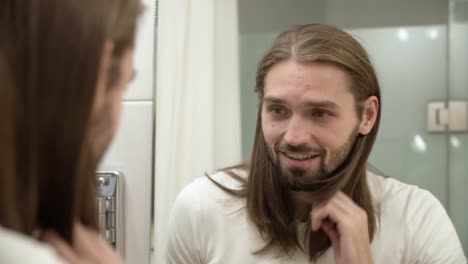 Hombre-en-el-baño-mirando-en-el-espejo-y-tocarse-la-cara