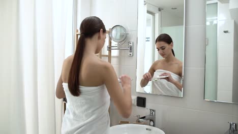 Salud-dental.-Mujer-cepillado-de-los-dientes-en-el-baño