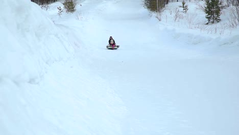 Woman-and-Girl-Riding-Fast-on-a-Sledding-Tubing