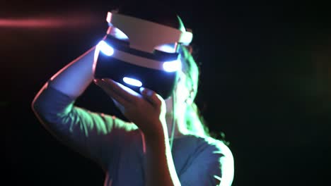 Girl-in-defocus-holding-and-putting-on-VR-headset