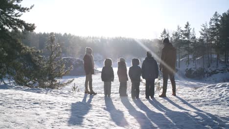 Große-Familie-bewundert-Schneefaus-Winterlandschaft