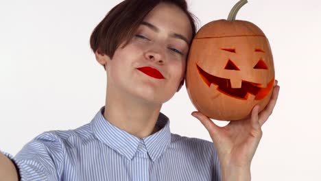 Schöne-rote-Lippen-Frau-macht-Selfies-mit-geschnitzten-Halloween-Kürbis