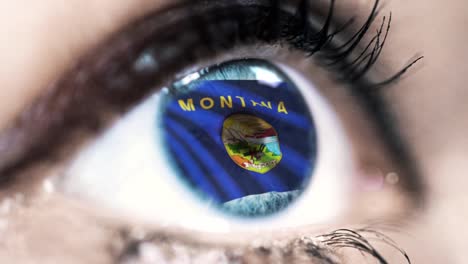 Mujer-ojo-azul-en-primer-plano-con-la-bandera-del-estado-de-Montana-en-iris,-estados-unidos-de-América-con-movimiento-de-viento.-concepto-de-vídeo