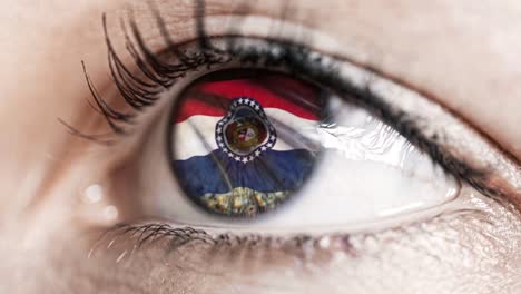 Woman-green-eye-in-close-up-with-the-flag-of-Missouri-state-in-iris,-united-states-of-america-with-wind-motion.-video-concept