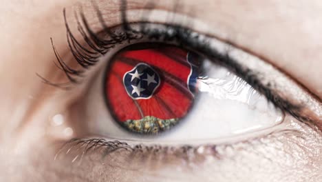 Woman-green-eye-in-close-up-with-the-flag-of-Tennessee-state-in-iris,-united-states-of-america-with-wind-motion.-video-concept