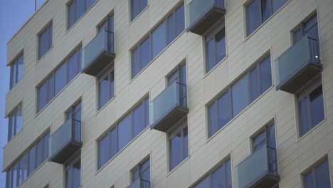 Foto-de-cerca-del-moderno-edificio-residencial.-Edificio-residencial-exterior-con-fondo-celeste-azul.-El-edificio-cuenta-con-exterior-con-pequeños-balcones