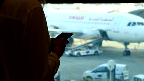 Business-woman-chatting,-texting-on-smart-phone-while-waiting-at-airport-terminal