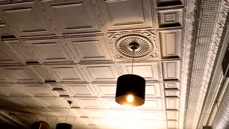Luz-de-cabeza-dorada-en-restarant-victoriana-contra-hermoso-techo