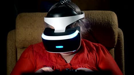 Elderly-woman-in-front-of-TV-screen-uses-VR-headset-and-wireless-gaming-controller