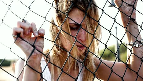 Sad-and-frustrated-woman-imprisoned-behind-a-net---slow-motion