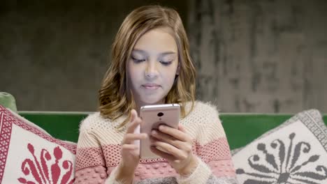 Teen-girl-chat-with-friend-by-smartphone-at-home