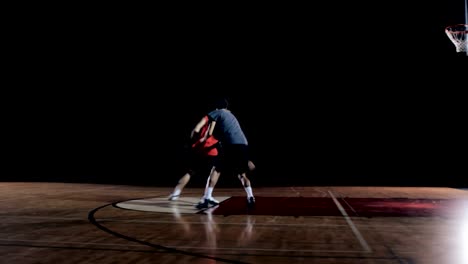 Ein-Basketball-Spieler-macht-einen-Zug-auf-Verteidiger-und-tunkt-den-Ball.