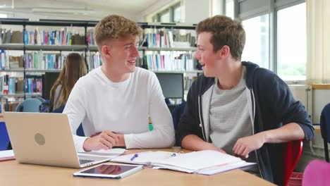 Zwei-männliche-College-Studenten,-die-Arbeiten-am-Laptop-zusammen-In-Bibliothek