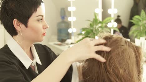 Peluquería-de-mujer-haciendo-masaje-cabeza-joven-en-salón-de-peluquería.-Cerca-de-haircutter-trabajando-con-cliente-en-salón-de-belleza