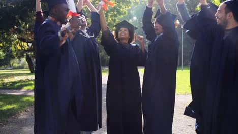 glückliche-Schüler-in-Mörtel-Boards-mit-Diplomen