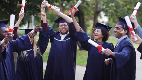 happy-students-in-mortar-boards-with-diplomas