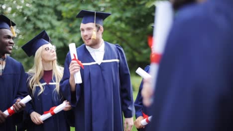 glückliche-Schüler-in-Mörtel-Boards-mit-Diplomen