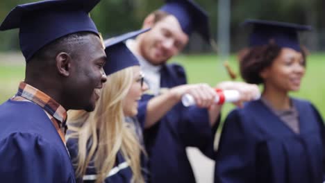 glückliche-Schüler-in-Mörtel-Boards-mit-Diplomen