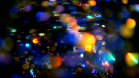 Defokussierten-schillernden-bunten-Glitter-Konfetti,-schwarzer-Hintergrund.-Urlaub-abstrakte-festliche-Bokeh-Lichtpunkte.