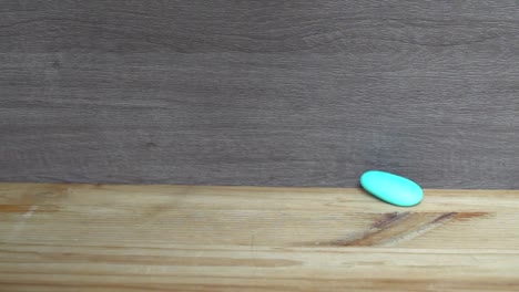 Dekorative-blaue-Stein-fallen-auf-dem-Holztisch.