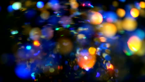 Defocused-shimmering-multicolored-glitter-confetti,-black-background.-Holiday-abstract-festive-bokeh-light-spots.