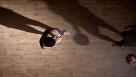 Topshot,-zwei-Basketball-Spieler-eins-zu-eins-auf-Platz-drinnen-spielen