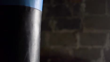 Man-hitting-punching-bag-at-the-gym-with-boxing-gloves-on.