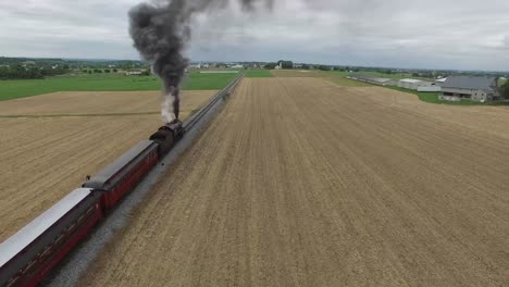 Tren-locomotora-resoplando-a-lo-largo-de-campo