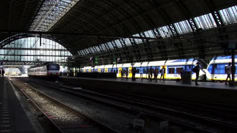 Silhouette-der-Passagiere-zu-Fuß-auf-der-Plattform-an-Bord-ein-Zuges-in-Amsterdam-Central-Station-in-Europa.