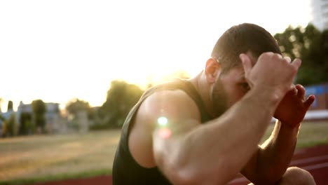 Portrait-of-strong-young-man-in-sport-shorts-and-T-shirts-boxing-and-punching-invisible-opponent-while-training-outdoors,-slow-motion