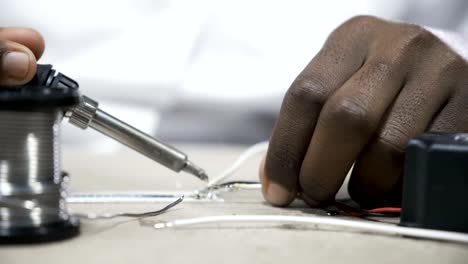 Hands-soldering-wires-at-work