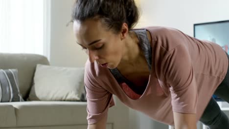 Mujer-haciendo-flexiones-durante-sesión-de-entrenamiento-en-línea