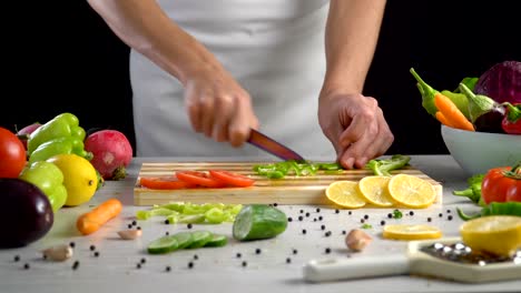 Chef-is-cutting-vegetables-in-the-kitchen,-slicing-green-bell-pepper