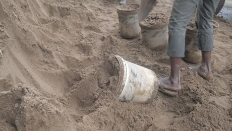 Using-a-shovel-to-put-sand-into-a-bucket-(-close-up)