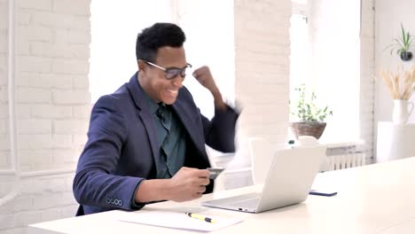 Successful-Online-Shopping-via-Credit-Card-on-Laptop-by-African-Man