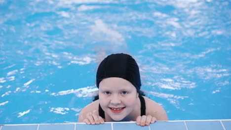 clases-de-natación-para-niños-en-la-piscina---hermosa-chica-de-piel-clara-nada-en-el-agua