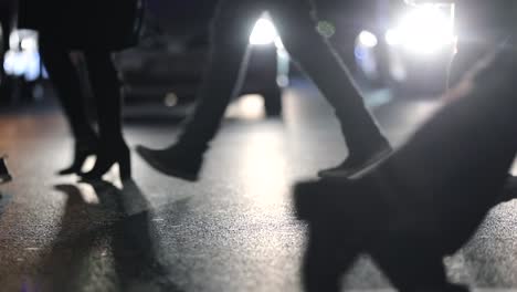 Pedestrians-feet-crossing-street-at-night-at-120fps-slow-motion.-Commuters-walking-during-rush-hour