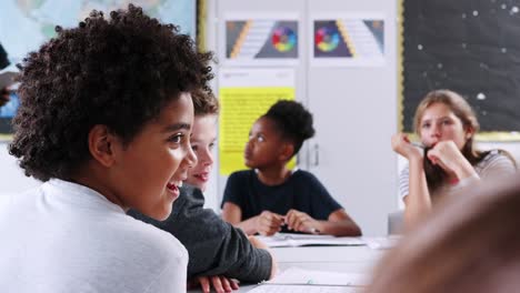 Estudiantes-de-secundaria-en-respuesta-a-la-maestra-pregunta-en-clase