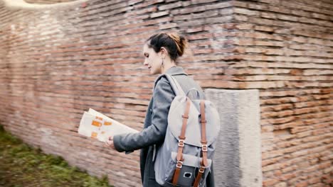 Camera-follows-young-excited-traveler-woman-with-backpack-expolring-ancient-historic-red-brick-ruins-of-Ostia,-Italy.