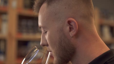 Portrait-of-handsome-male-sniffing-wine-in-the-glass-close-up-in-profile-Man-admires-alcohol-drink