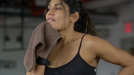 Mujer-joven-sana-hermosa-forma-limpiando-el-sudor-con-la-toalla-después-de-ejercicio-intensivo-entrenamiento-en-gimnasio.-Filmada-en-cámara-lenta.