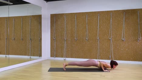 Young-woman-stretching-in-yoga-studio-with-copy-space