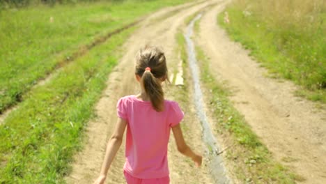 Little-girl-walking-along-a-rural-road
