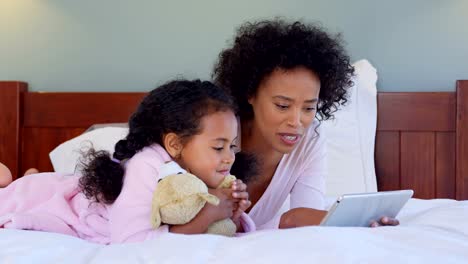 Front-view-of-black-mother-and-daughter-using-digital-tablet-at-comfortable-home-4k