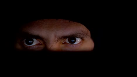 Male-Hacker-in-Hat-Working-on-Laptop-Monitor-at-Night