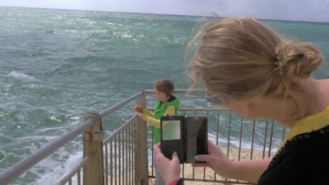 Mama-macht-Zelle-Foto-von-Kind-blick-auf-das-Meer.-Rosch-Hanikra