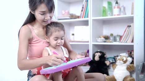 Mother-is-teaching-daughter-to-write-letters.