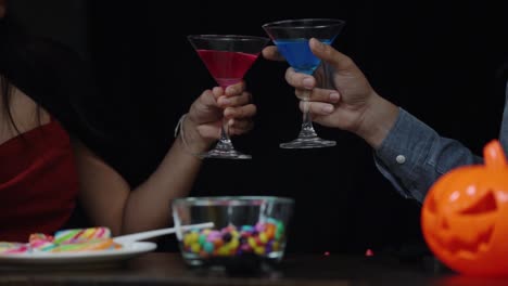 Couple-in-Halloween-costume-celebrating-with-glass-of-liquor-in-Halloween-night-party